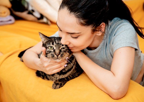 a woman is cuddling her black cat